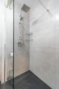 a shower with a glass door in a bathroom at Green Sea Apartamenty Kasprowicza in Kołobrzeg