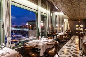un restaurant avec des tables et des chaises et une grande fenêtre dans l'établissement Palais Faraj Suites & Spa, à Fès