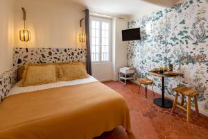 una camera da letto con un grande letto e carta da parati floreale di Le Saint Victor Coeur de Cannes a Cannes