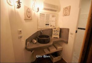 a bathroom with a sink in the corner of a room at Maison Bersane in Le Poujol-sur-Orb