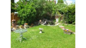 a backyard with a table in the grass at Camelot Retreat - Tor View in Glastonbury