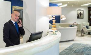 un hombre hablando por celular en una tienda en Erbavoglio Hotel en Rímini