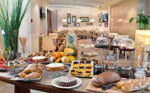 ein Tisch voller verschiedener Brotsorten und Gebäckstücke in der Unterkunft Erbavoglio Hotel in Rimini