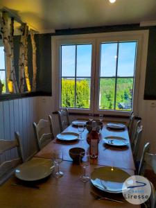 uma mesa de jantar com cadeiras e uma grande janela em Chalet la Liresse em Rochehaut