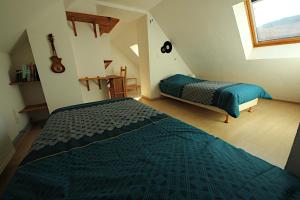 Un dormitorio con 2 camas y una guitarra. en Chambres et table d'hôte Le Petit Radis en Lus-la-Croix-Haute