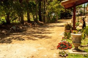 a dirt path with a statue and flowers in a park at Pousada Villa Aurora in Serra Negra