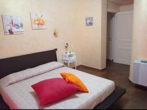 1 dormitorio con 1 cama con almohadas de color rojo y naranja en B&b kabbala club, en Lattarico