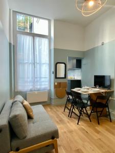 a living room with a couch and a table at Studio Aboukir 1 in Paris