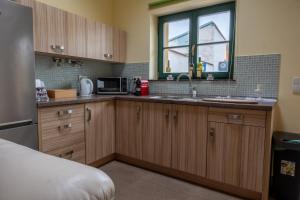 a kitchen with wooden cabinets and a sink and a window at Pension Max Valtice in Valtice