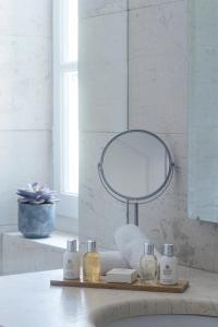 een badkamerbar met een spiegel en een wastafel bij The Kefalari Suites in Athene
