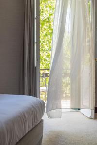 a bedroom with a bed and a large window at The Kefalari Suites in Athens