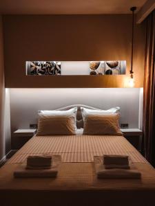 a bedroom with a bed with two towels on it at Alto Suite (Cielo suites) in Kavala