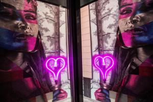 a window with neon pink hearts on it at Hotel Indigo Madrid - Gran Vía by IHG in Madrid