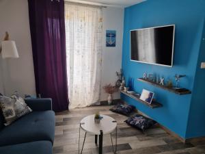 ein blaues Wohnzimmer mit einem Sofa und einem Tisch in der Unterkunft Apartment LELA in Šibenik