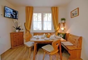 uma sala de jantar com uma mesa e cadeiras e uma janela em Ferienhaus Ahorn em Mittelberg