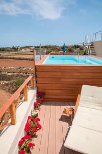 a deck with flowers and a swimming pool at Tal-Karmnu Entire house with private heated pool and jacuzzi in Kirkop