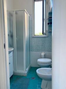a bathroom with a toilet and a shower and a sink at Appartamento Lamù in Santa Maria di Castellabate