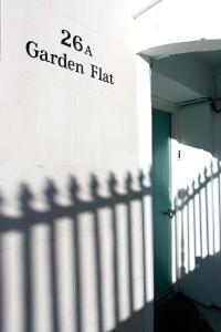 a sign for a garden flat on the side of a building at Central Hastings, Stylish-Luxe, Seaside Apartment. in Hastings