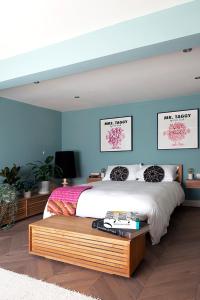 a bedroom with a large bed with blue walls at Central Hastings, Stylish-Luxe, Seaside Apartment. in Hastings