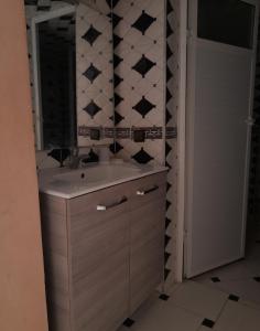 een badkamer met een wastafel en een spiegel bij Appartement Ouargaga in Meknès