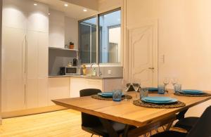 图卢兹Confort Appartement 110 m² CleanNcosy Toulouse Hypercentre的配有木桌的厨房和餐厅