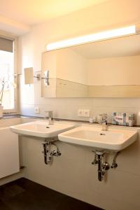 a bathroom with two sinks and a large mirror at Bayerischer Hof in Heiligenberg