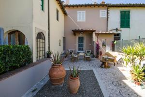 cortile con piante in vaso di fronte a un edificio di Poggio al Sole a Montespertoli