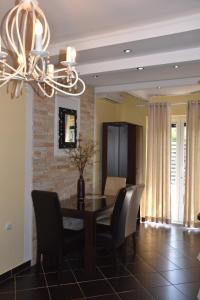 uma sala de jantar com uma mesa e cadeiras e um lustre em Apartments Scepanovic em Tivat