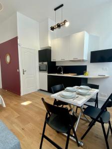 a kitchen with a table and chairs in a room at Studio Aboukir 2 in Paris