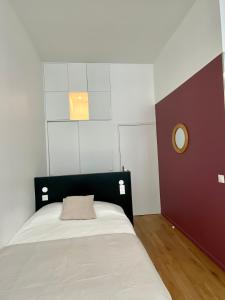 Dormitorio pequeño con cama con manta marrón en Studio Aboukir 2 en París
