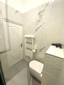 La salle de bains blanche est pourvue de toilettes et d'un lavabo. dans l'établissement Studio Aboukir 2, à Paris