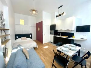 a small apartment with a bed and a table and chairs at Studio Aboukir 2 in Paris