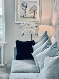 a blue couch with white pillows in a living room at Cotswold Chic Retreats "Cloud Nine" Central Chipping Campden-Parking-Garden in Chipping Campden +21 photos