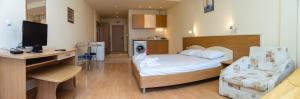 Un dormitorio con una cama y un escritorio con televisión. en Studio with a balcony near the centre of Sunny Beach by Flаt Manаger, en Sunny Beach