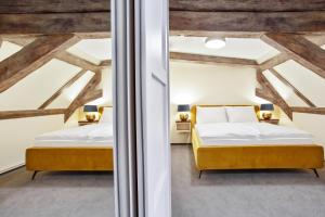 2 Betten in einem Zimmer mit Holzdecken in der Unterkunft Zámecký penzion in Poděbrady