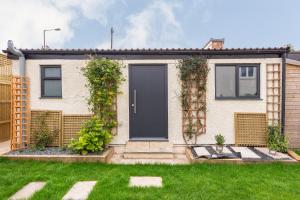 a house with a black door and a yard at The Nook in Bristol