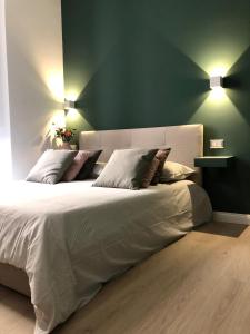 una camera da letto con un grande letto con pareti verdi di NSH AppartHotel, Napoli Centro a Napoli