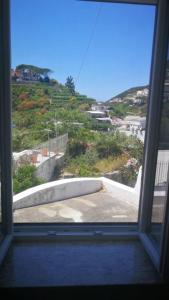 a window looking out at a view of a hill at Visitponza - La casa di Eolo in Ponza +25 photos