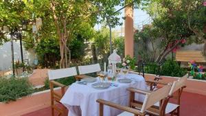 a table with a white table cloth on it with chairs at Villa titika in Argostoli