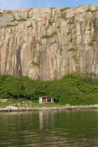 una pequeña casa en la orilla de un cuerpo de agua en Hamburgö en Hamburgsund