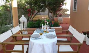a table with a white table cloth and wine glasses at Villa titika in Argostoli +23 photos