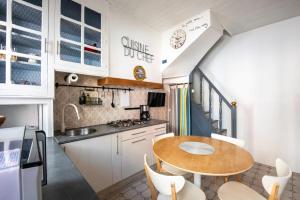 a small kitchen with a wooden table and chairs at Maison de pêcheur LE TREPORT "ça nous va" in Le Tréport