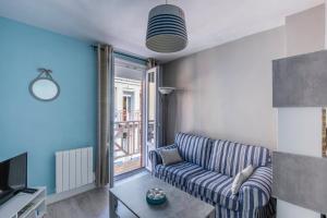 a living room with a couch and a tv at Maison de pêcheur LE TREPORT "ça nous va" in Le Tréport