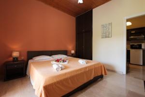 ein Schlafzimmer mit einem Bett mit Handtüchern und Blumen darauf in der Unterkunft Erifili Apartments in Sidari
