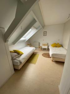 een slaapkamer op zolder met 2 bedden en een bank bij Vakantiewoning in Middelburg Zeeland in Middelburg