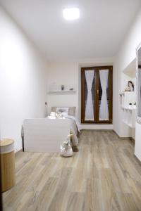 1 dormitorio con cama blanca y suelo de madera en La Piega, en Collepardo