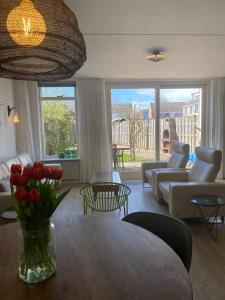 Una sala de estar con una mesa con un jarrón de flores. en Vakantiewoning in Middelburg Zeeland, en Middelburg 24 fotos más