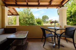 a patio with a table and chairs and a window at Erifili Apartments in Sidari