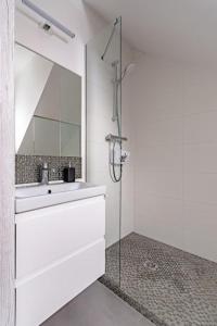 a bathroom with a sink and a glass shower at Apartament Kapitańska in Niechorze