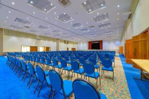 a large room with blue chairs and a podium at Pousada dos Pireneus in Pirenópolis